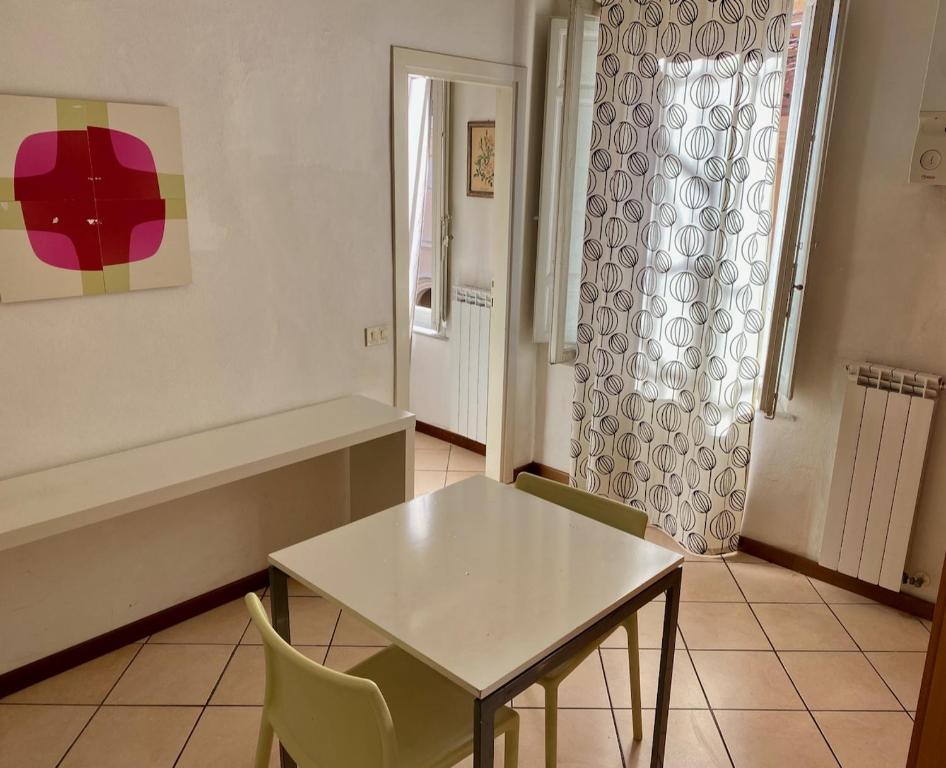 un tavolo bianco con sedie in una stanza con finestra di Appartamento in centro：Montecatini Terme a Montecatini Terme