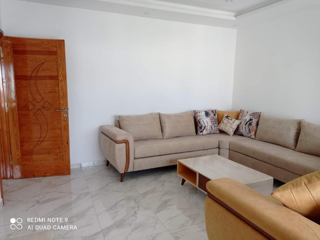 uma sala de estar com um sofá e uma mesa de centro em Eline em Rafrāf