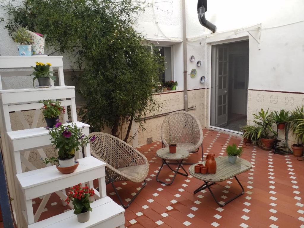 eine Terrasse mit Korbstühlen, Tischen und Pflanzen in der Unterkunft The Jasmine House in Olvera