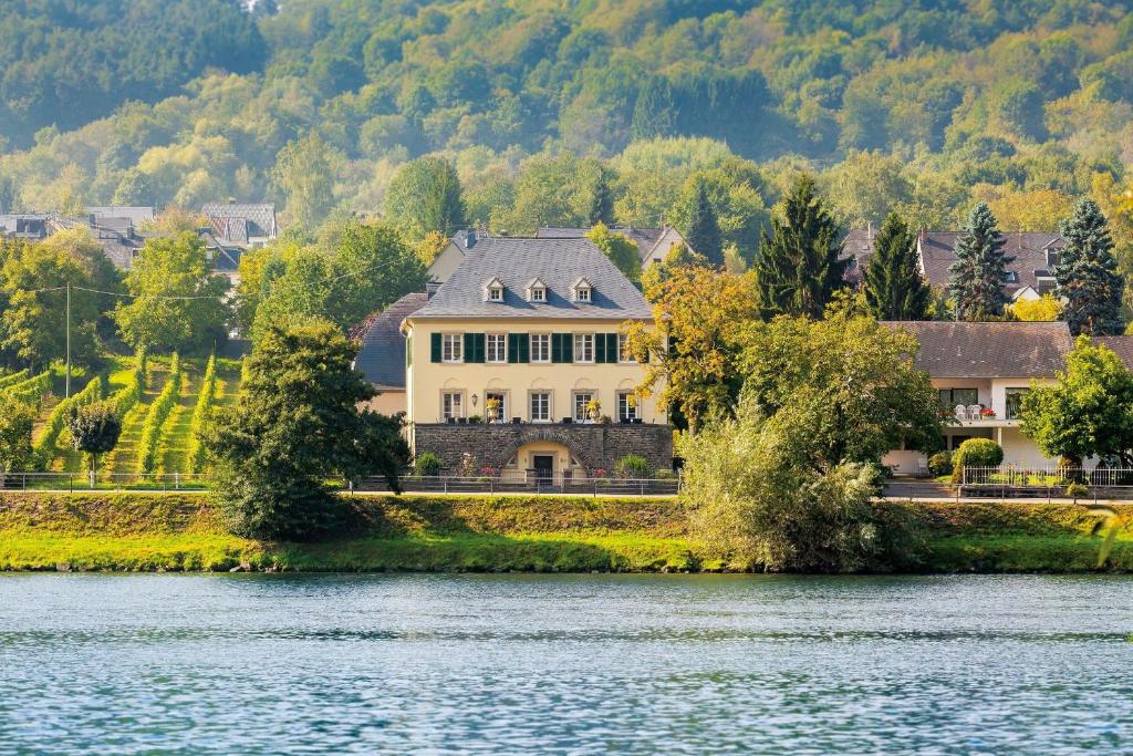 ein großes Haus am Ufer eines Sees in der Unterkunft Wein- und Landhaus S A Prüm in Bernkastel-Kues