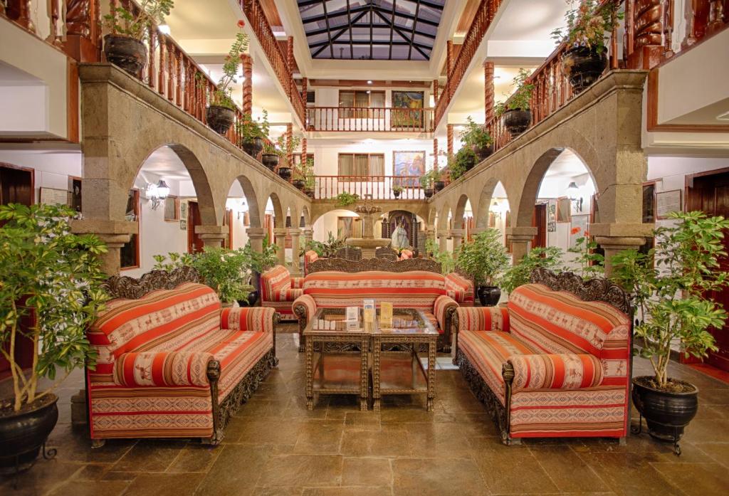 a lobby with couches and tables and potted plants at Munay Wasi Inn in Cusco
