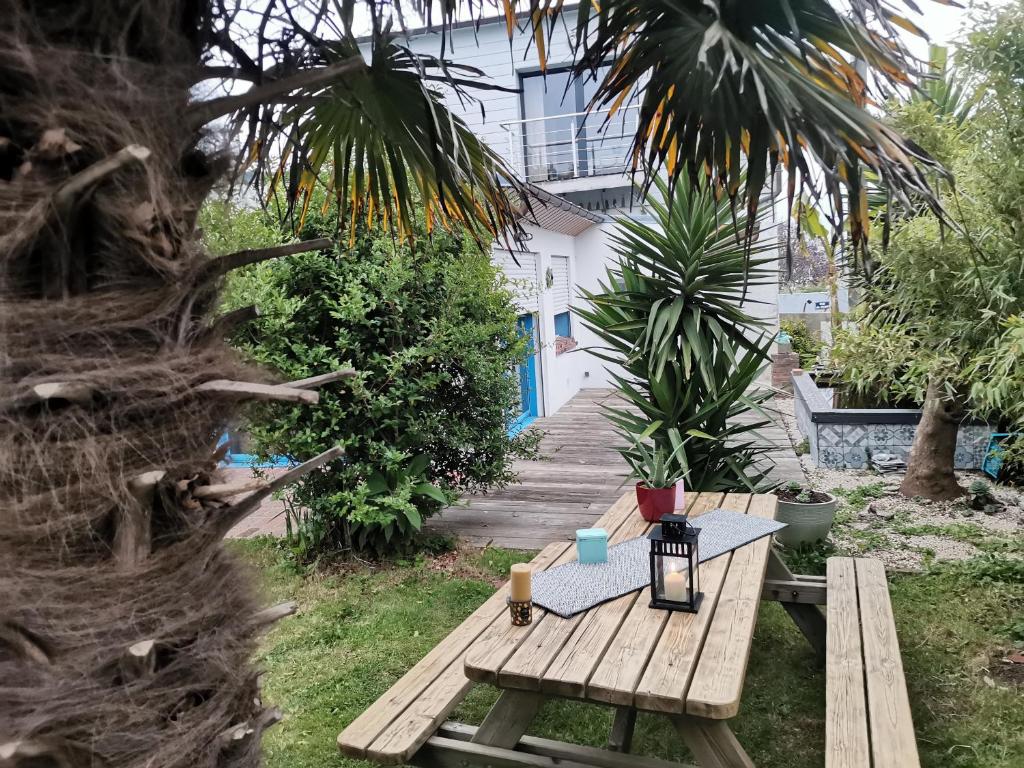 una mesa de picnic de madera en un patio con una casa en A quelques pas du moulin blanc, en Brest