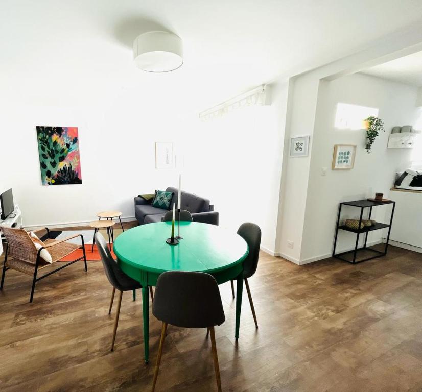 ein Wohnzimmer mit einem grünen Tisch und Stühlen in der Unterkunft Au perron avec garage et balcon à Ribeauville in Ribeauvillé