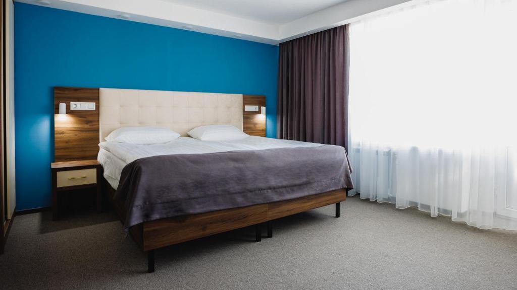 una camera con un grande letto con una parete blu di Park Hotel a Tiraspol