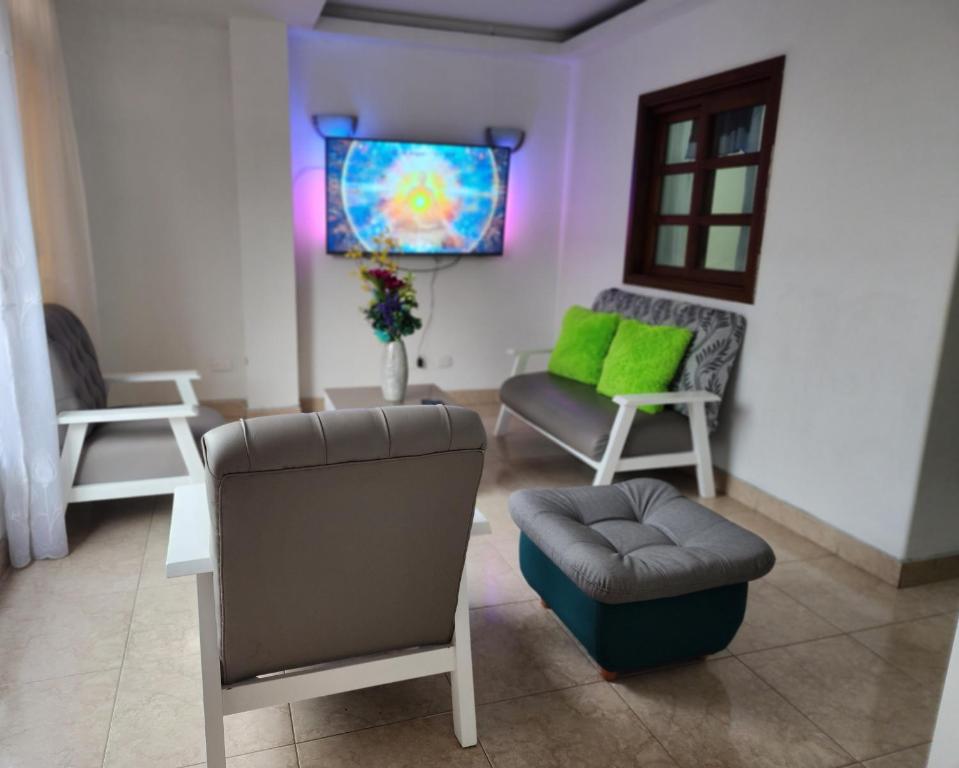 sala de estar con silla y TV en Espléndido apto completo en el centro de Pereira, en Pereira