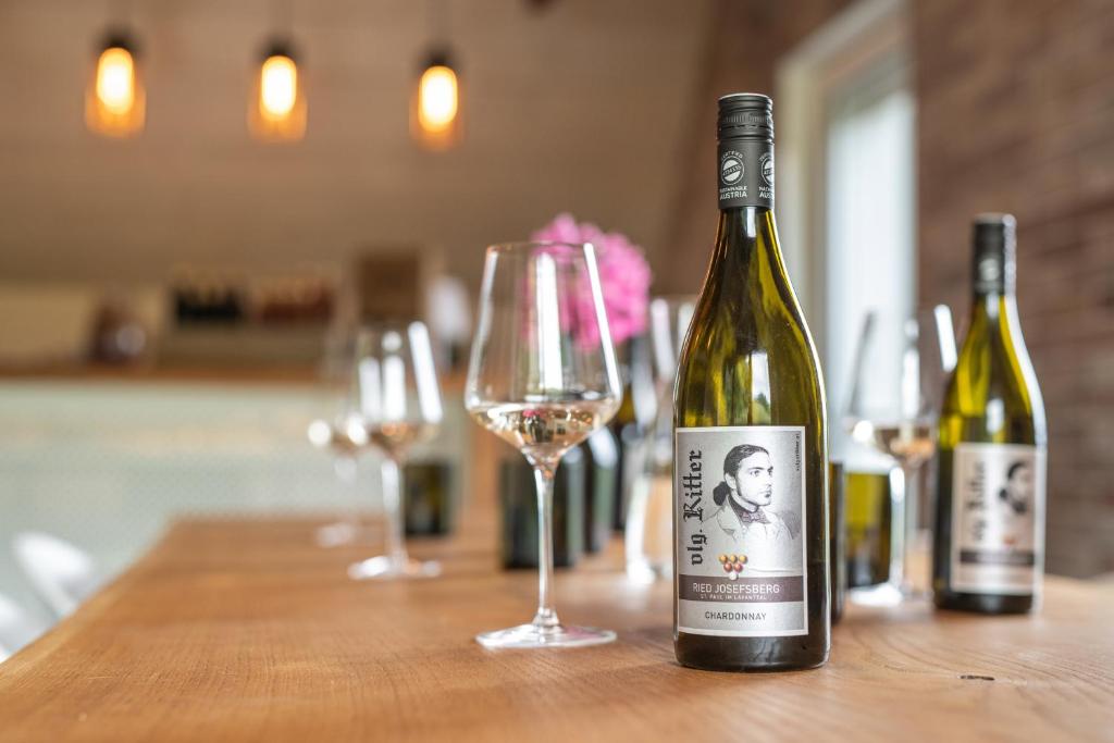 two bottles of wine sitting on a table with a glass at Auszeit am Weinhof in Loschenthal