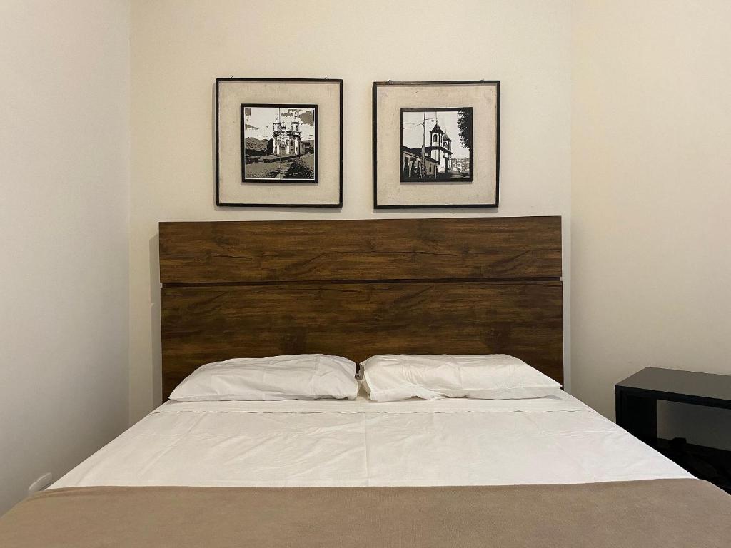 una camera con un letto con tre immagini appese al muro di Locking's Lourdes 8 a Belo Horizonte