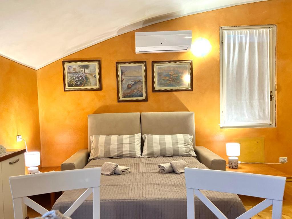 una camera con un letto in una stanza con pareti arancioni di La Ninfea di Luca a due passi da Sirmione a San Martino della Battaglia