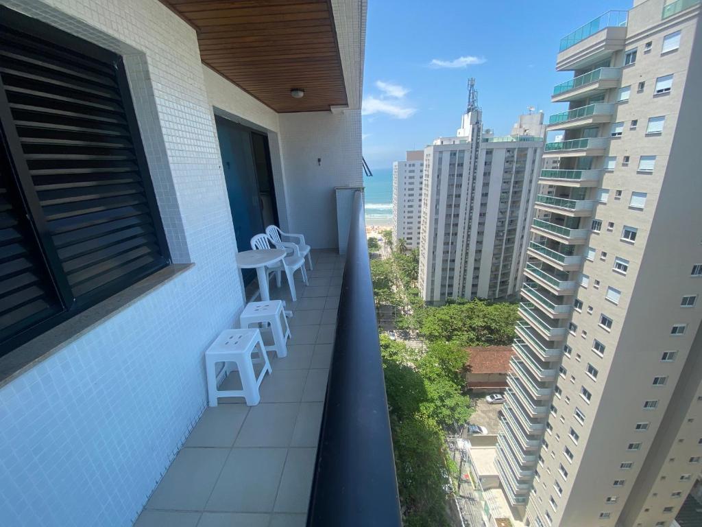 un balcone con 2 sedie e un tavolo su un edificio di Guarujá, Pintangueiras, Flat a Guarujá