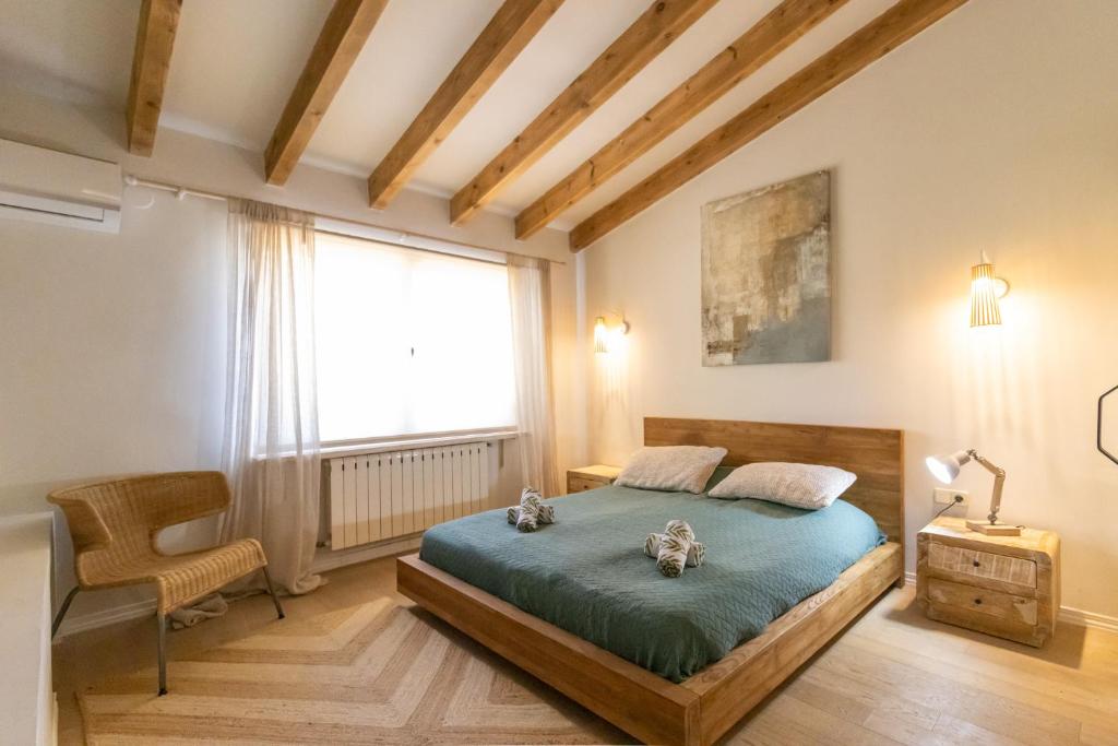 um quarto com uma cama, uma cadeira e uma janela em Casa Algarrobo em Xàbia