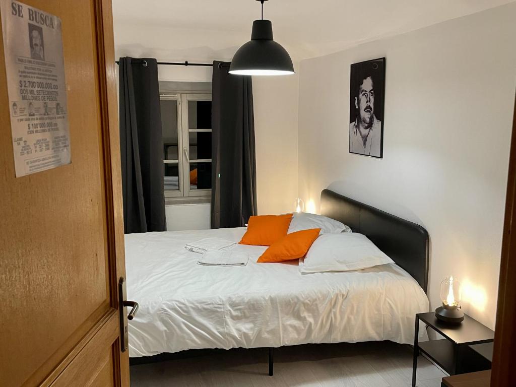 ein Schlafzimmer mit einem Bett mit orangefarbenen Kissen in der Unterkunft Prison dorée 52m2 à la frontière du Luxembourg 5P in Sierck-les-Bains