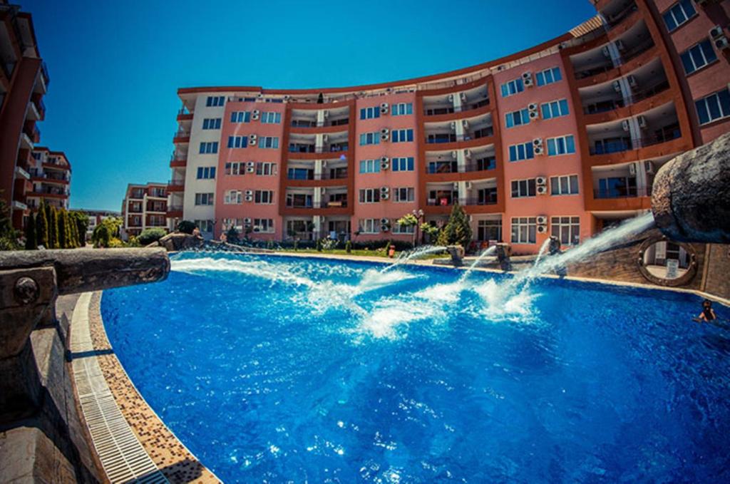 una piscina con una fuente frente a un edificio en Privilege Fort Beach - Menada Apartments, en Elenite