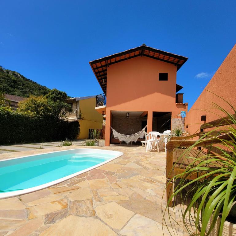 Villa con piscina frente a una casa en Partiu Praia SC en Guarda do Embaú