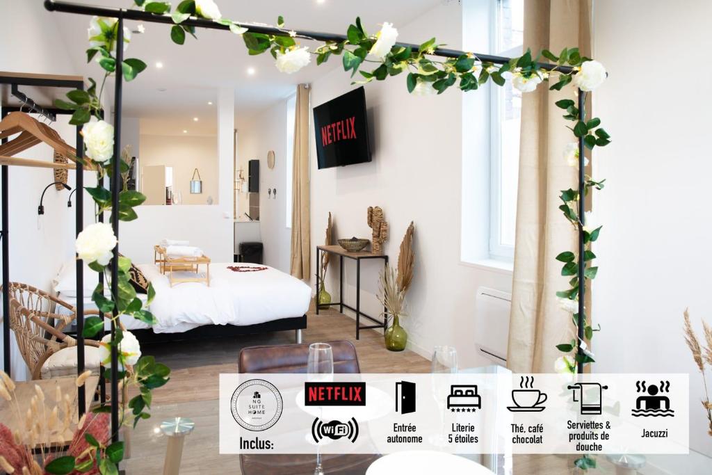 a living room with a bed and a floral arch with flowers at NG SuiteHome - Lille I Tourcoing Winoc - Balnéo - Netflix - Wifi in Tourcoing