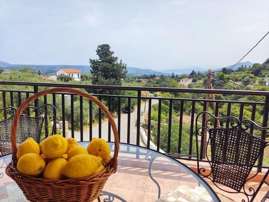 a basket of lemons on a glass table on a balcony at Koukos House surrounded by nature in Frés
