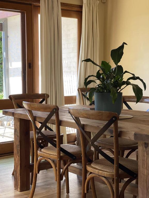 Una mesa de madera con sillas y una planta en maceta encima. en Residence on Cemar - Home Away from Home, en Orange