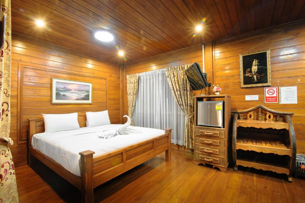 um quarto com uma cama e uma televisão em Denchaicity Resort เด่นชัยซิตี้ รีสอร์ท em Phrae