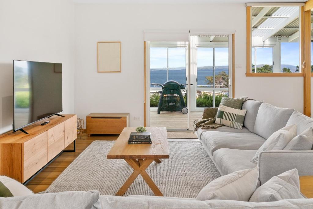 a living room with a couch and a tv at Blue Cottage Bruny Island in Alonnah
