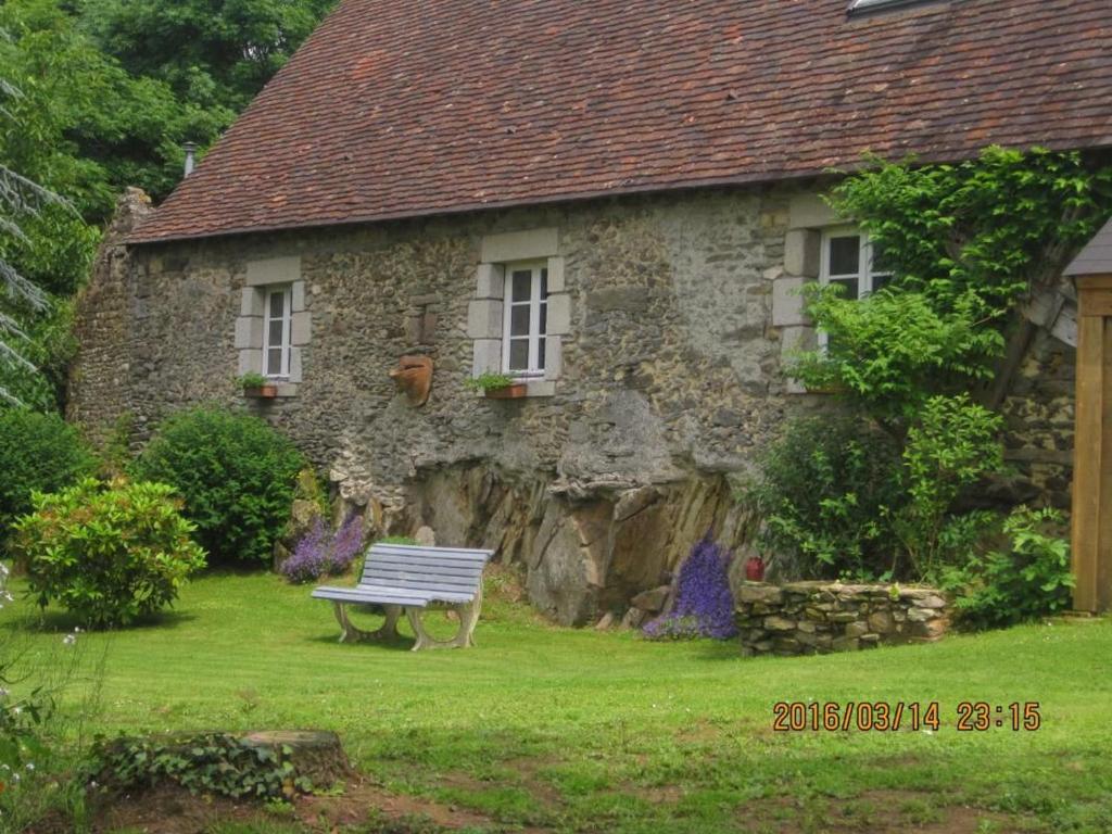 a stone house with a bench in front of it at Charmante maison de campagne avec vaste parc arboré, cheminée et multiples activités à proximité - FR-1-410-153 in Moulins-le-Carbonnel