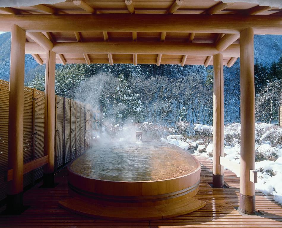 einem großen Brunnen auf einer Holzterrasse in der Unterkunft Nishiyama Onsen Keiunkan in Hayakawa