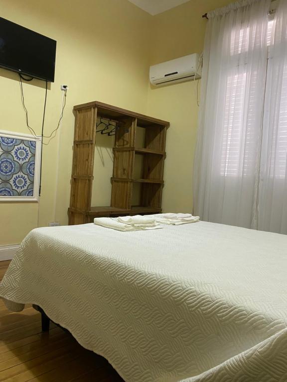 a bedroom with a white bed and a window at Hosteria San Martin in San Salvador de Jujuy