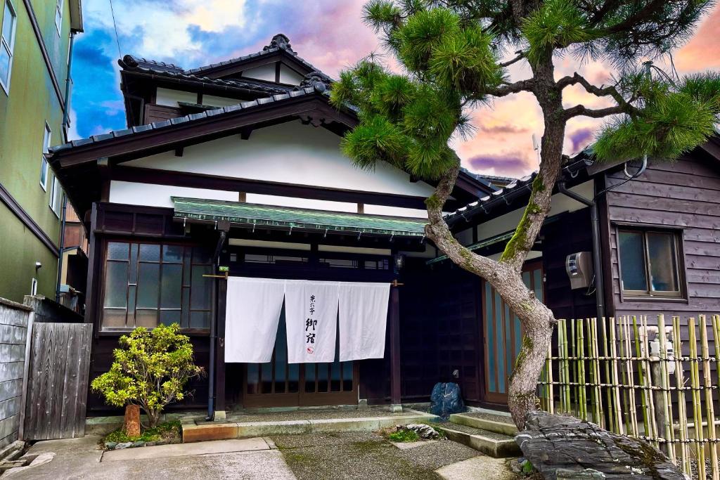 une maison avec des serviettes blanches suspendues devant elle dans l'établissement Kenrokutei Oyado, à Kanazawa