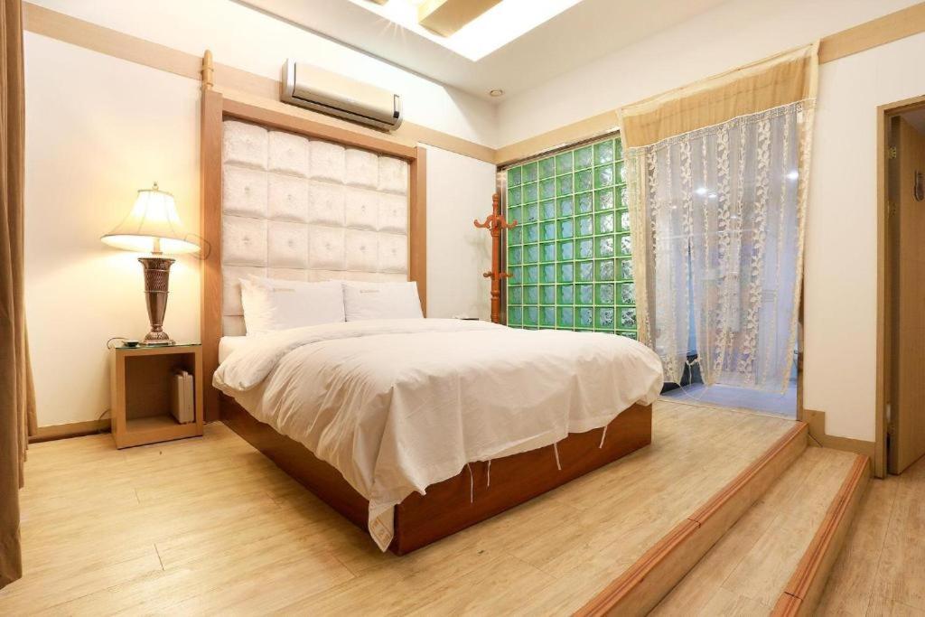 a bedroom with a large bed and a window at Carlton Hotel in Paju