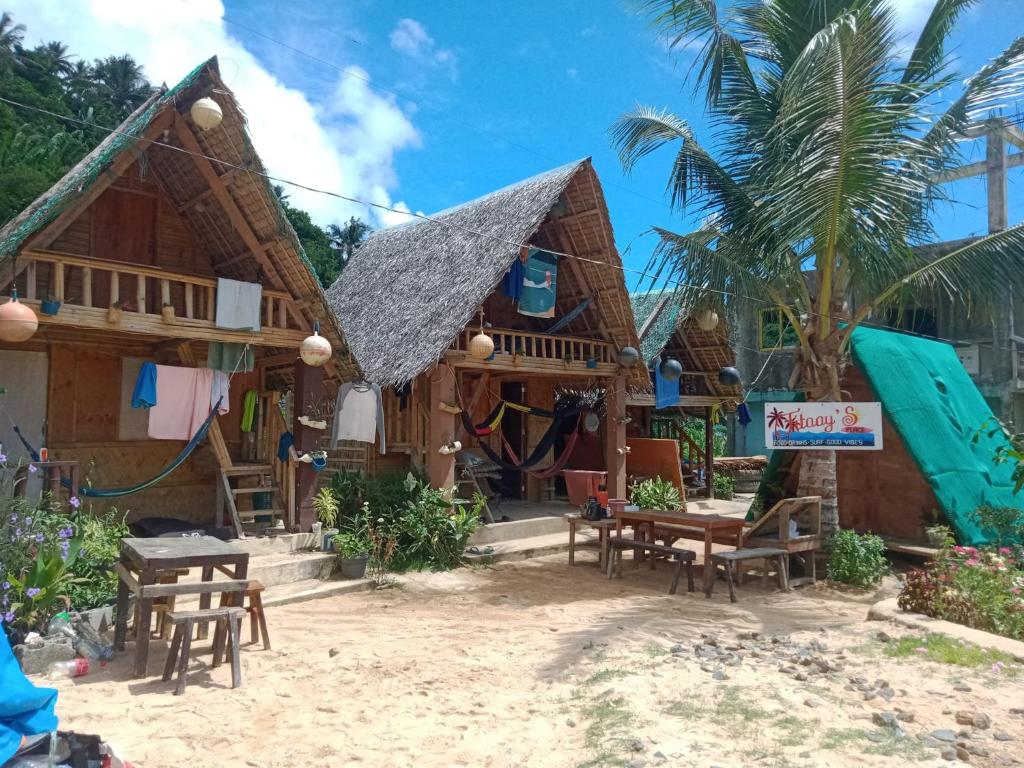 ein Resort am Strand mit Stühlen und Tischen in der Unterkunft Titaays Surfers Inn in Baras