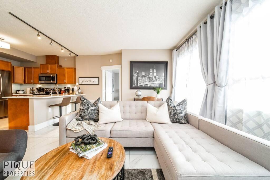 uma sala de estar com um sofá e uma mesa em Luxury Downtown Suite, River Valley View, Patio & BBQ, Sleeps 4 em Edmonton