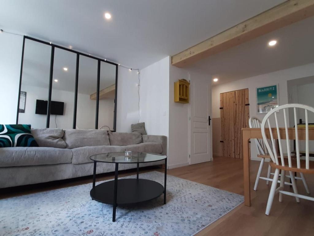 un salon avec un canapé et une table dans l'établissement Appartement cosy à Biarritz, proche des Halles et plages, idéal pour 2 avec wifi inclus - FR-1-239-853, à Biarritz
