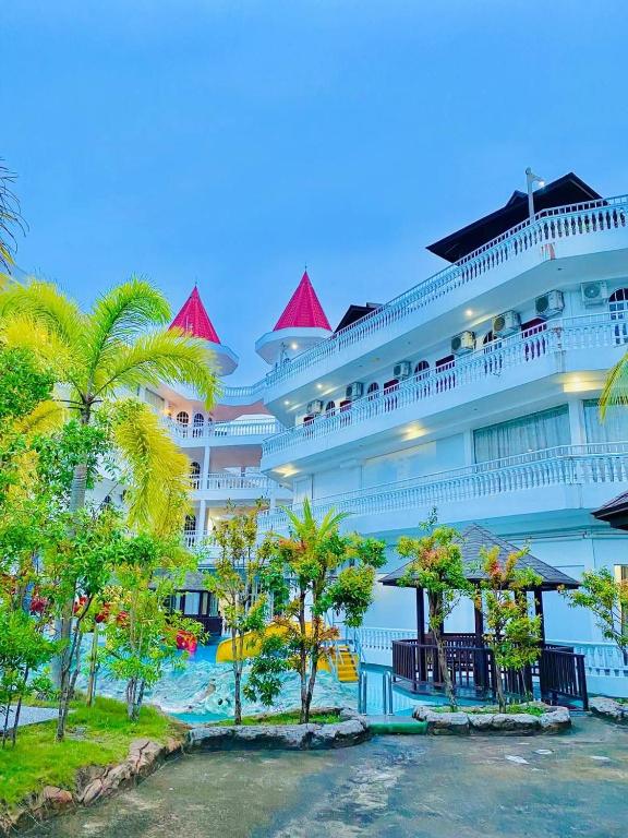 a large cruise ship with palm trees in front of it at Landcons Hotel & Resort in Pantai Cenang