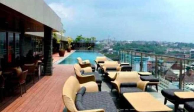 uma varanda com mesas e cadeiras e uma piscina em Cozy apartment in Louis kienne simpanglima em Semarang