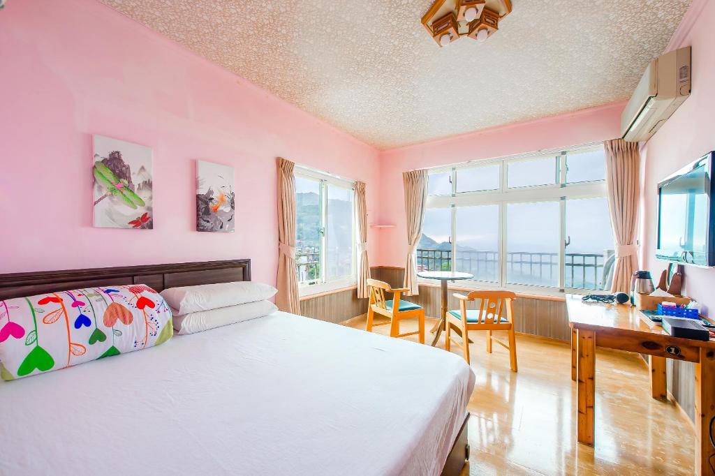 a bedroom with pink walls and a desk and a bed at Jiufen Kite Museum in Jiufen