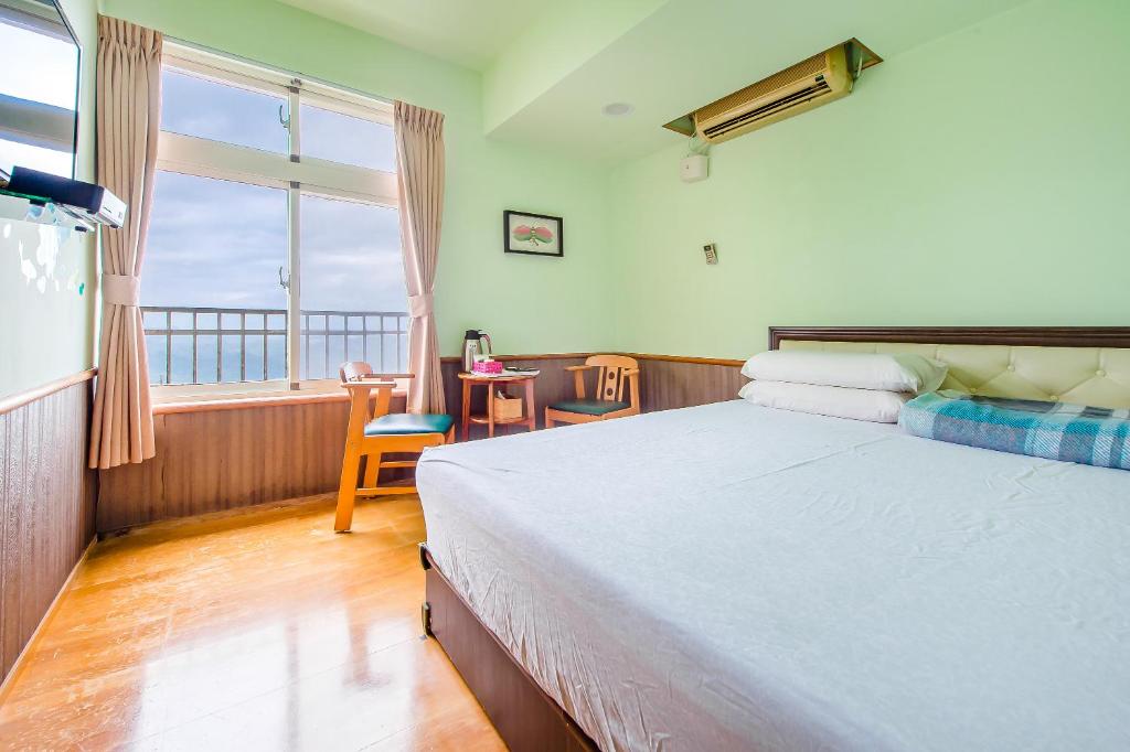 a bedroom with a bed and a view of the ocean at Jiufen Kite Museum in Jiufen