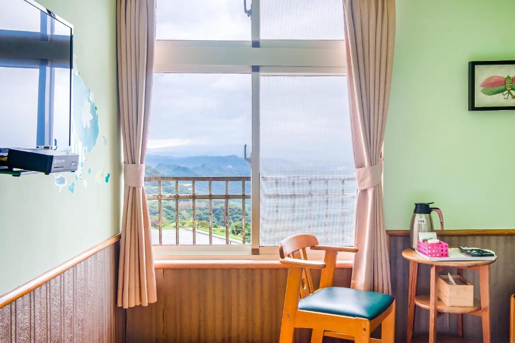a room with a large window and a table and chairs at Jiufen Kite Museum in Jiufen