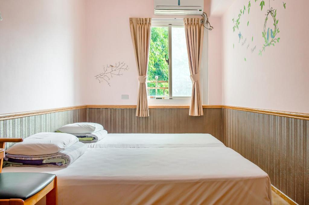 two beds in a room with a window at Jiufen Kite Museum in Jiufen