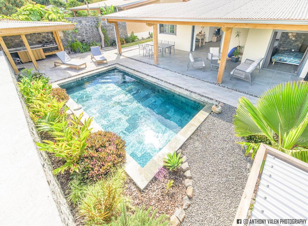 a swimming pool in the backyard of a house at Villa Fleur de Jade in Saint-Louis