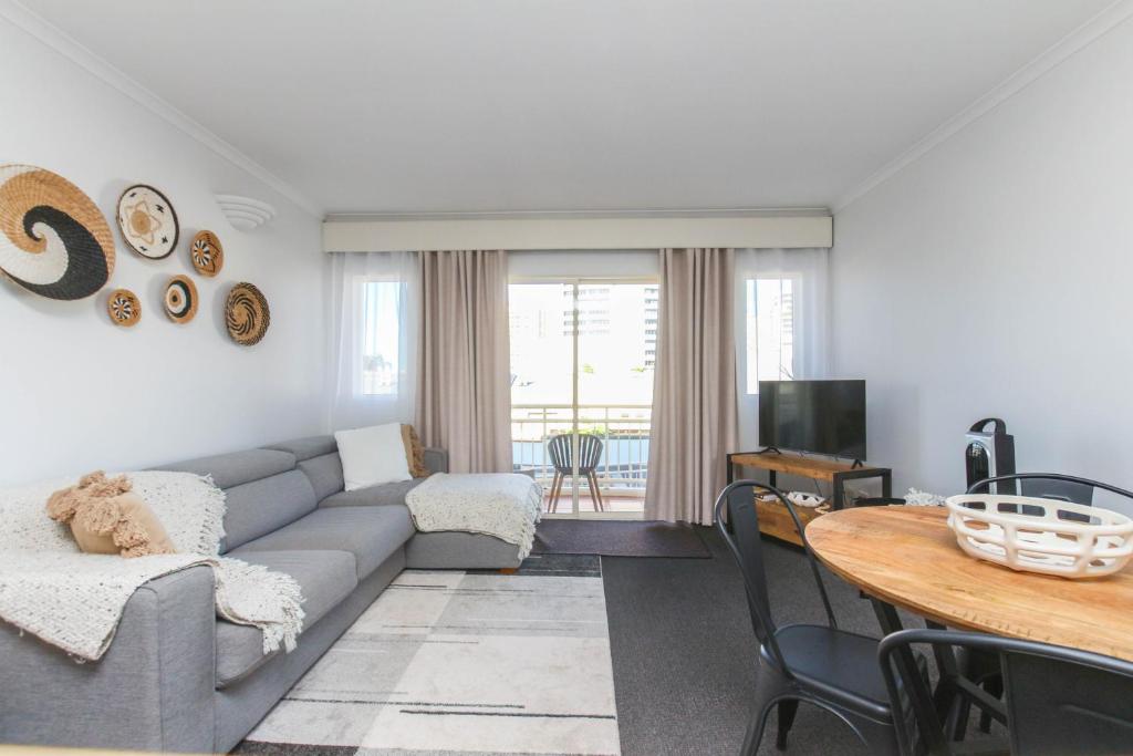 a living room with a couch and a table at Inner City One Bedroom Apartment with Pool View 22 in Cairns
