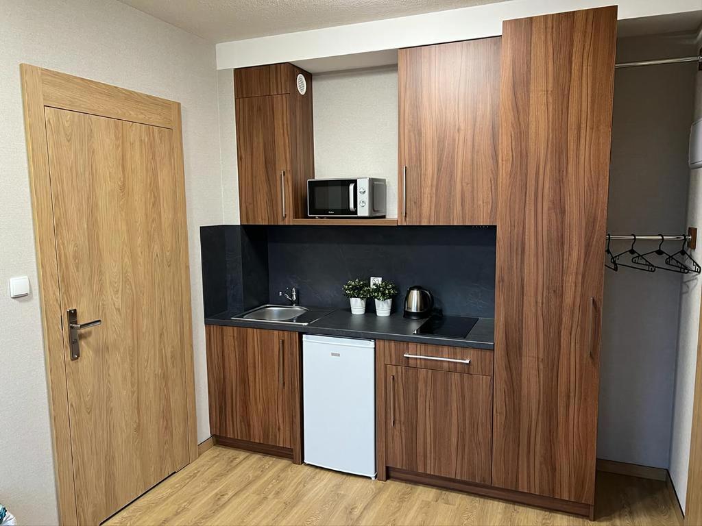a small kitchen with a sink and a microwave at Apartamenty Polna 60 in Żory