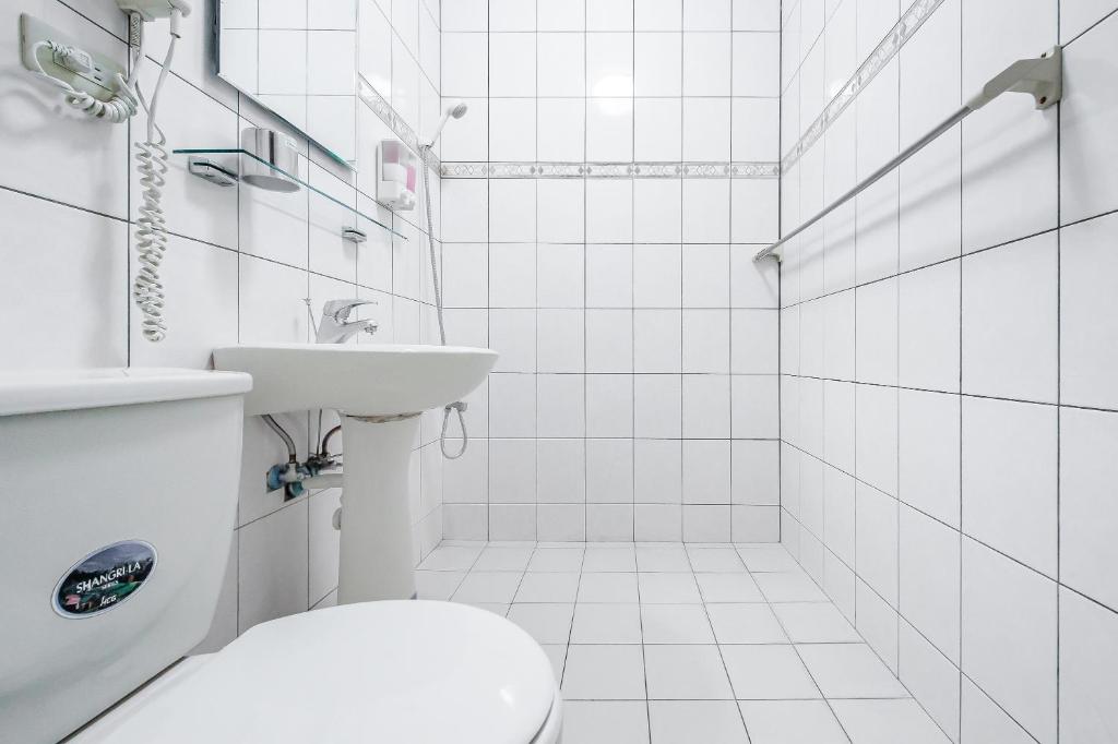 a white bathroom with a toilet and a sink at Jiufen Kite Museum in Jiufen