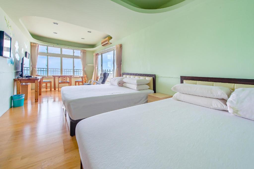 a hotel room with two beds and a table at Jiufen Kite Museum in Jiufen