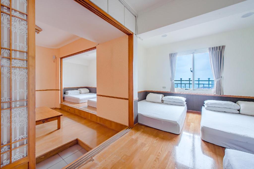 a room with two beds and a window at Jiufen Kite Museum in Jiufen