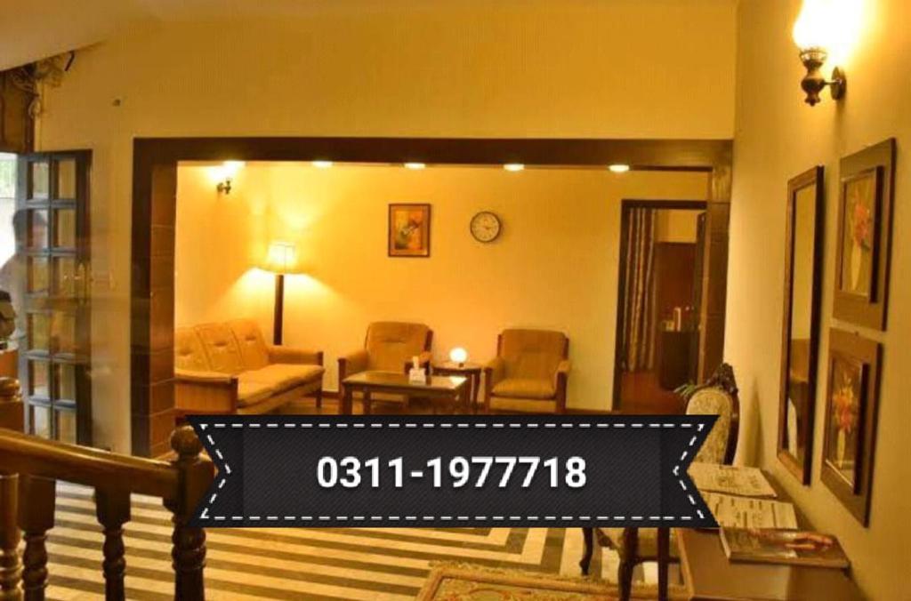 a living room with a sign that reads at Karachi Guest House - Gulshan in Karachi