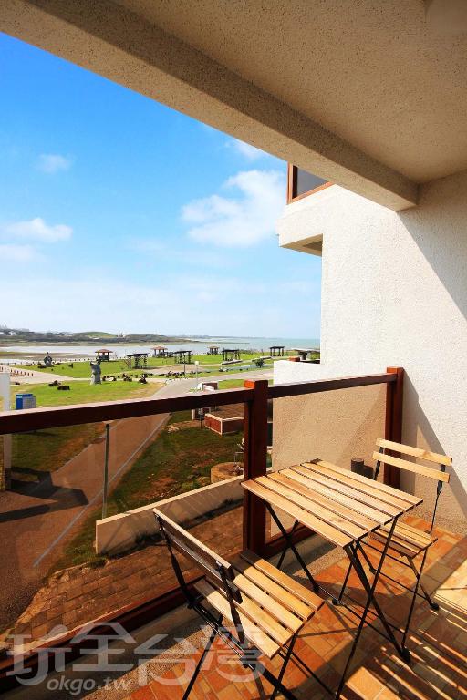 a balcony with a bench and a view of the beach at Malibu OceanView Homestay in Magong