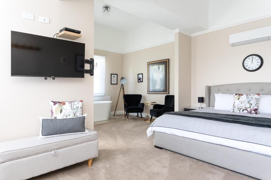 a bedroom with a bed and a tv on the wall at The Dragonfly Inn in Launceston