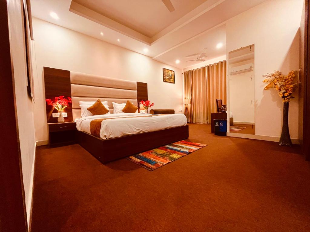 a bedroom with a large bed in a room at Hotel Prayag INN Haridwar in Haridwār