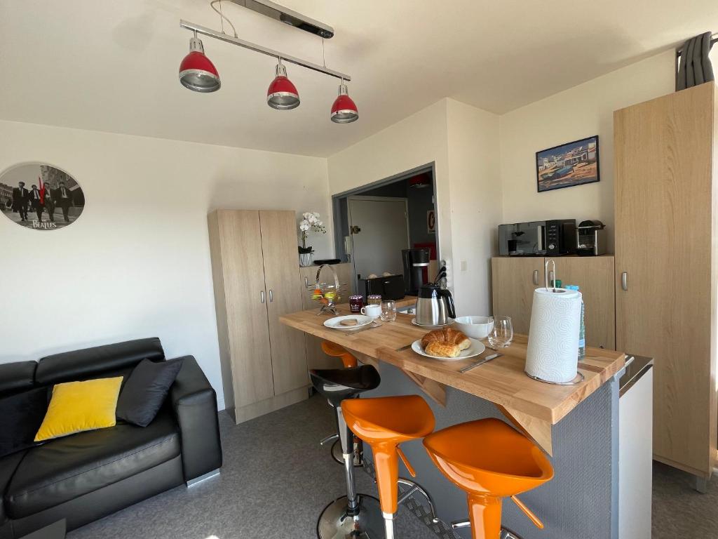 eine Küche und ein Wohnzimmer mit einem Tisch und Stühlen in der Unterkunft Appartement chaleureux , cosy, bien équipé et bien placé in Sedan