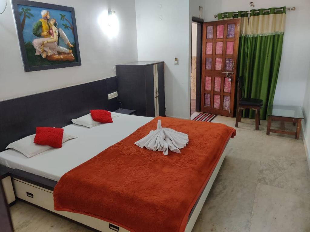 1 dormitorio con 1 cama grande con almohadas rojas en JAIN HOTEL,Pachmarhi, en Pachmarhī