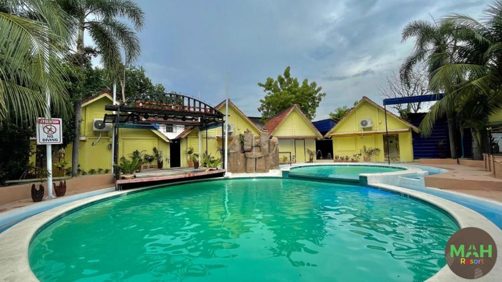 a swimming pool in front of a house at MAH Resort by Cocotel in Manila