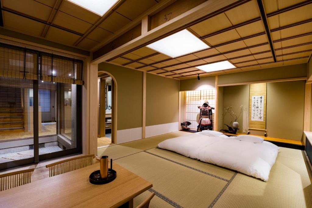 a room with a large bed in a room with a window at Ishibekoji Muan in Kyoto